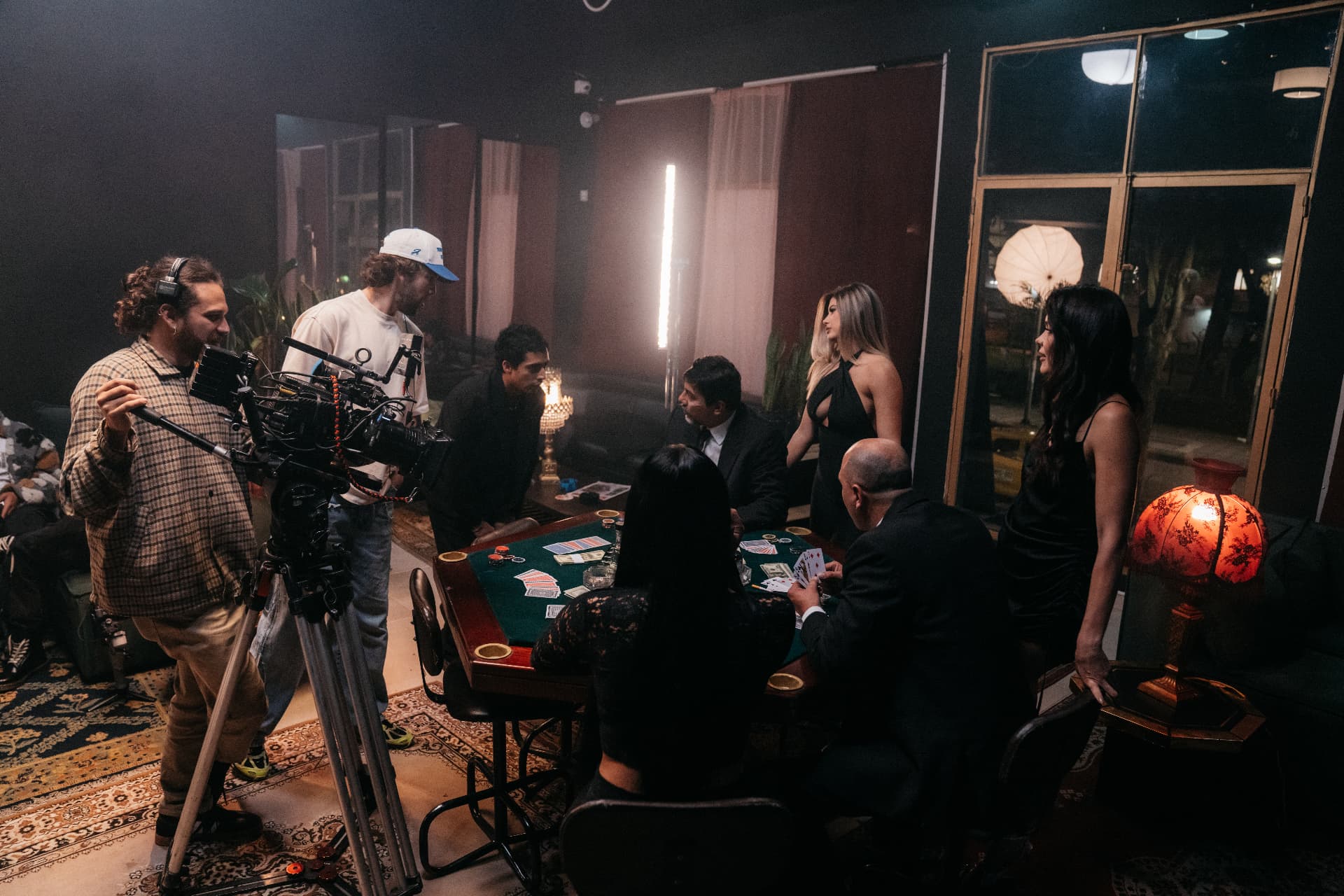 Film crew with camera and cast around a poker table on a night interior set